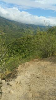 Pequena estrada de terra subindo uma colina ao lado da rodovia 25